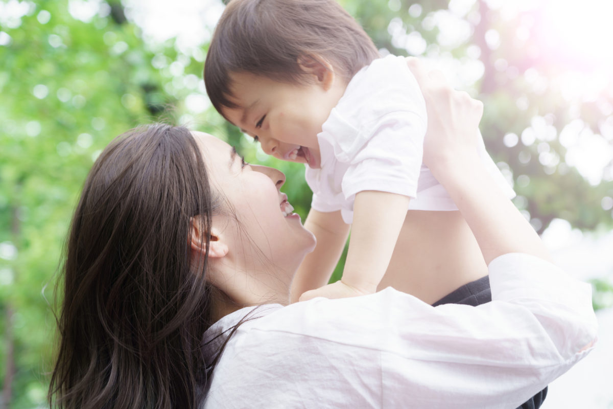 子どもを抱き上げる母